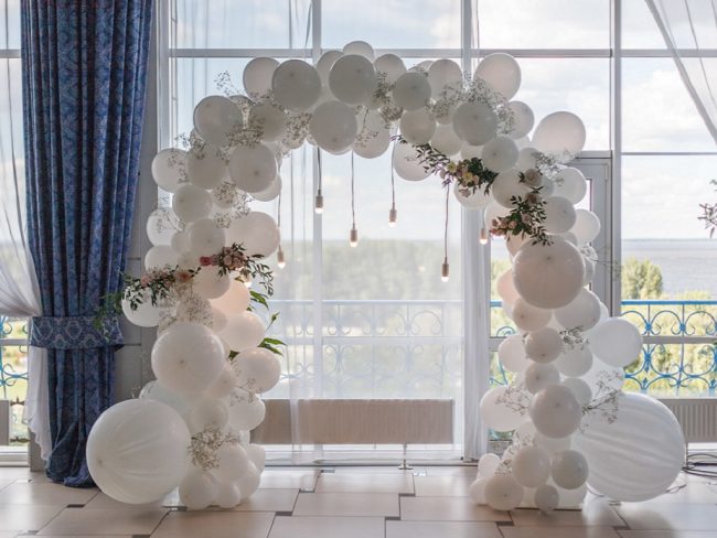 Nádherná svatební slavobrána z balónků v jemném bílém tónu s květinami