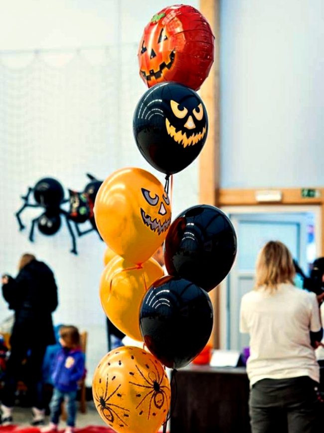 Strašidelné balónky, halloweenská výzdoba v oranžové a černé barvě. Halloweenský trs heliových balónků.