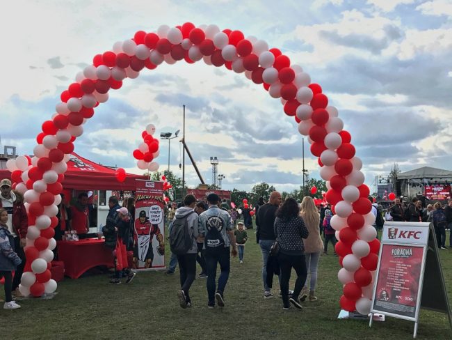 Velká balónková brána z červených a bílých balónků pro řetězec KFC
