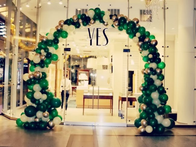 Nepravidelná brána z balónků jako dekorace při vstupu do prodejny YES, Luxisní balónková výzdoba v zelené, bílé a stříbrné barvě