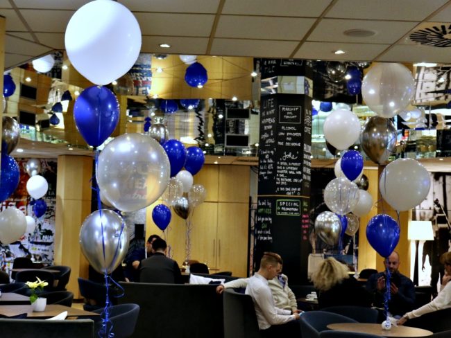 Heliové balónky v modré stříbrné a bílé barvě jako stolní instalace