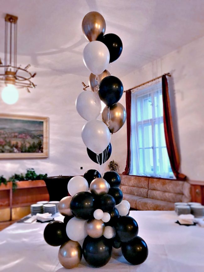 Nepravidelná černá, bílá a zlatá dekorace na stoly z héliových balónků.