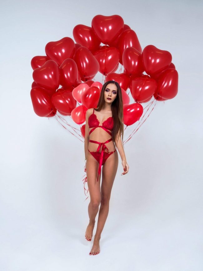 Modelk s trsem heliových balónků ve tvaru srdce, perfektní valentýnský dárek z balónků