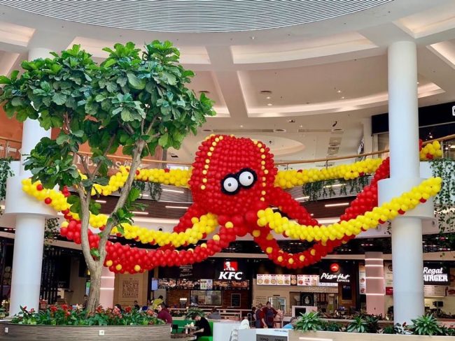 Obrovská balónková dekorace chobotnice s očima a chapadly v rámci balónkové výstavy v obchodním centru.
