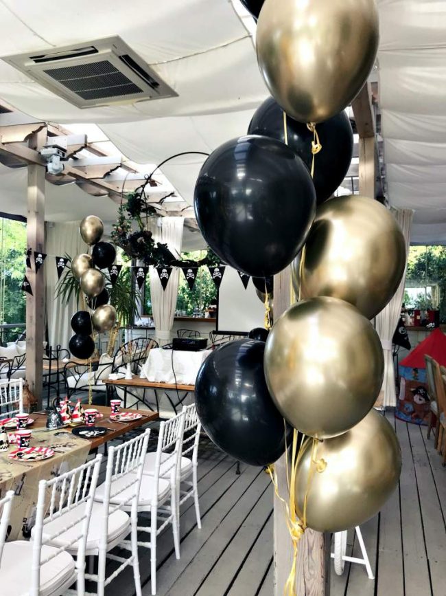 Balónková dekorace z trsů balónků v chromově zlatých a černých balónků pro zahradní party