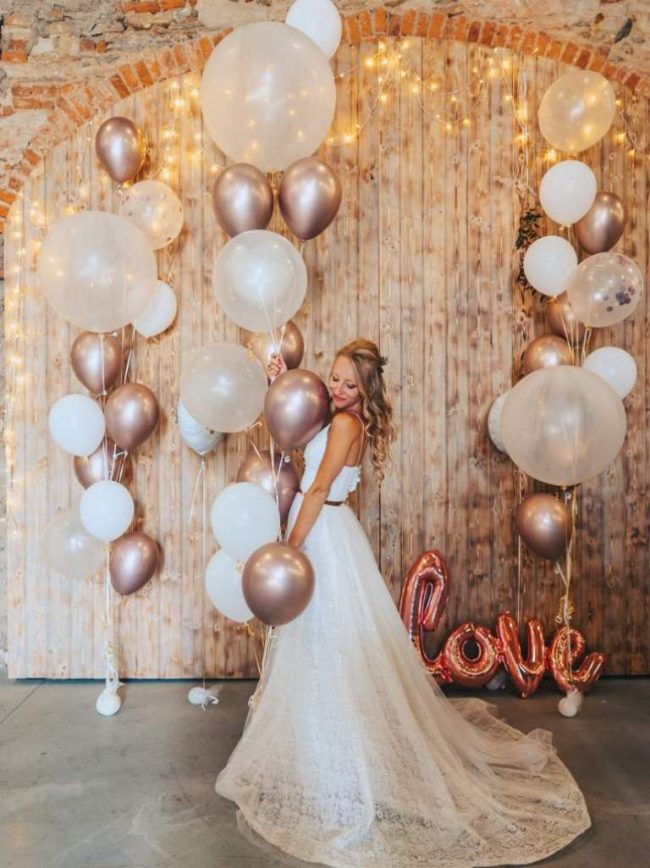 Krásná svatební dekorace složená z organických trsů balónků s héliem s prvky chromových balónků.