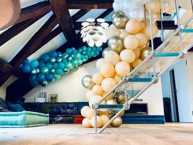 Monumentální organická balónková girlanda s chrom balónky upevněná v prostoru.