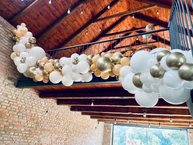Nádherná girlanda z balónků tvořená bílými a zářivě zlatými balónky pro umocnění slavnostního efektu ze svatební dekorace