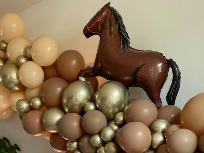 Nádherná balónková girlanda ze zlatých chromových balónků, hnědých balónků a krémových balónků a s dekorací koně z foliových balónků