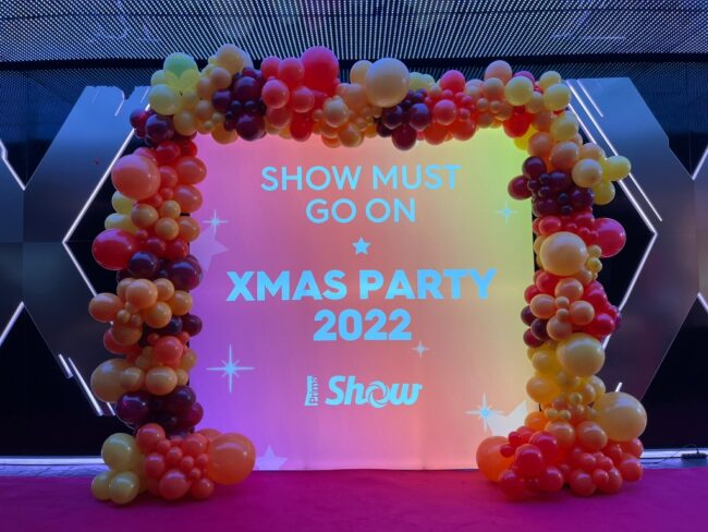 Balónková brána pro vánoční večírek pro Prima Show. Brána je tvořená z girlandy ze žlutých, červených, rudých a oranžových balónků.