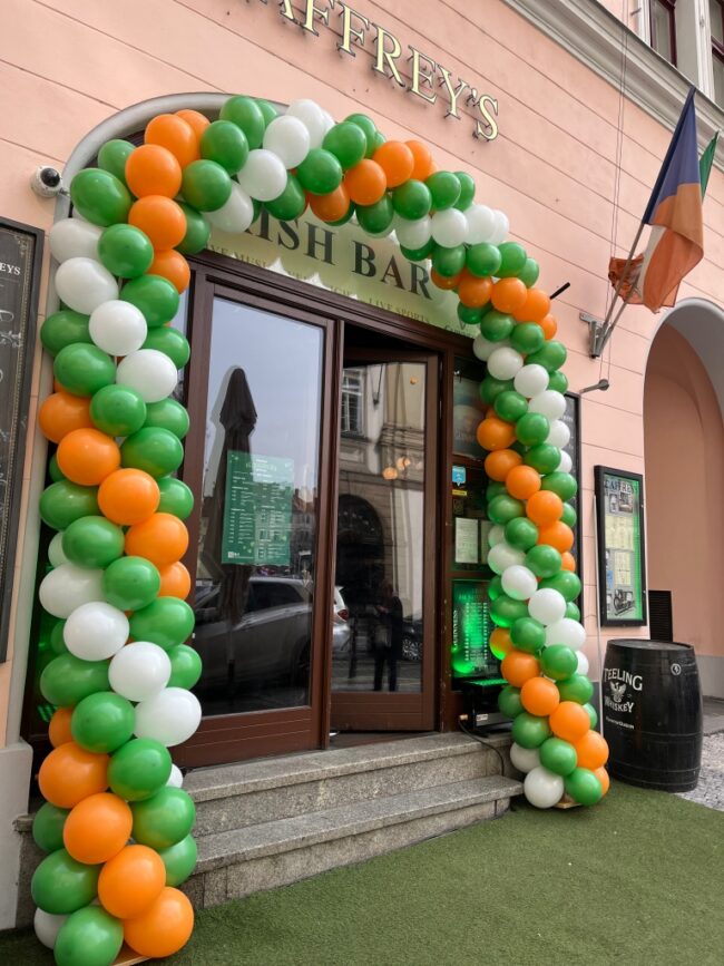 Brána z balónků se zelených, bílých a oranžových nafukovacích balónků na Svatého Patrika v Praze