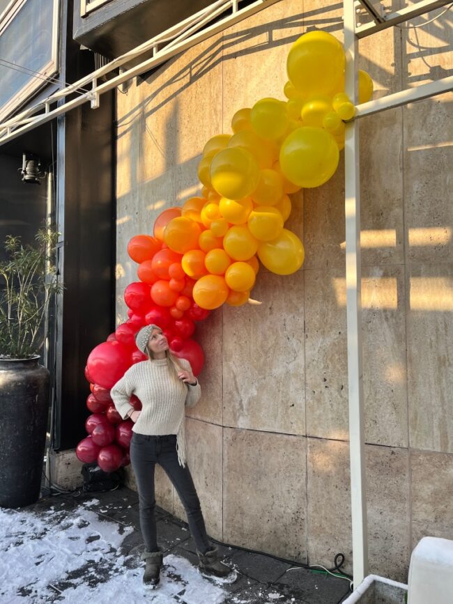Velký duhový balónkový řetěz v barvách žluté, červené, oranžové a rudé. Obrovská balónková dekorace