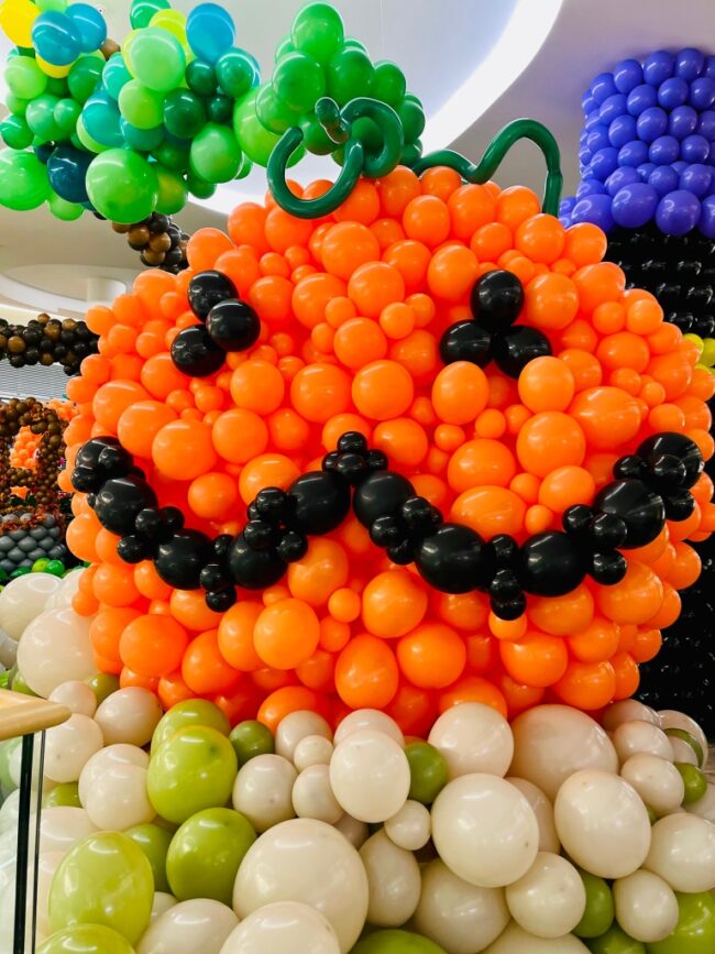 Obří balónková oranžová dýně s obličejem na halloweenské balónkové výstavě