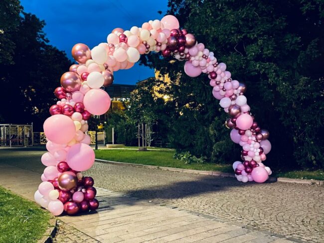Organický balónkový oblouk z různě velkých balónků v odstínech růžové.